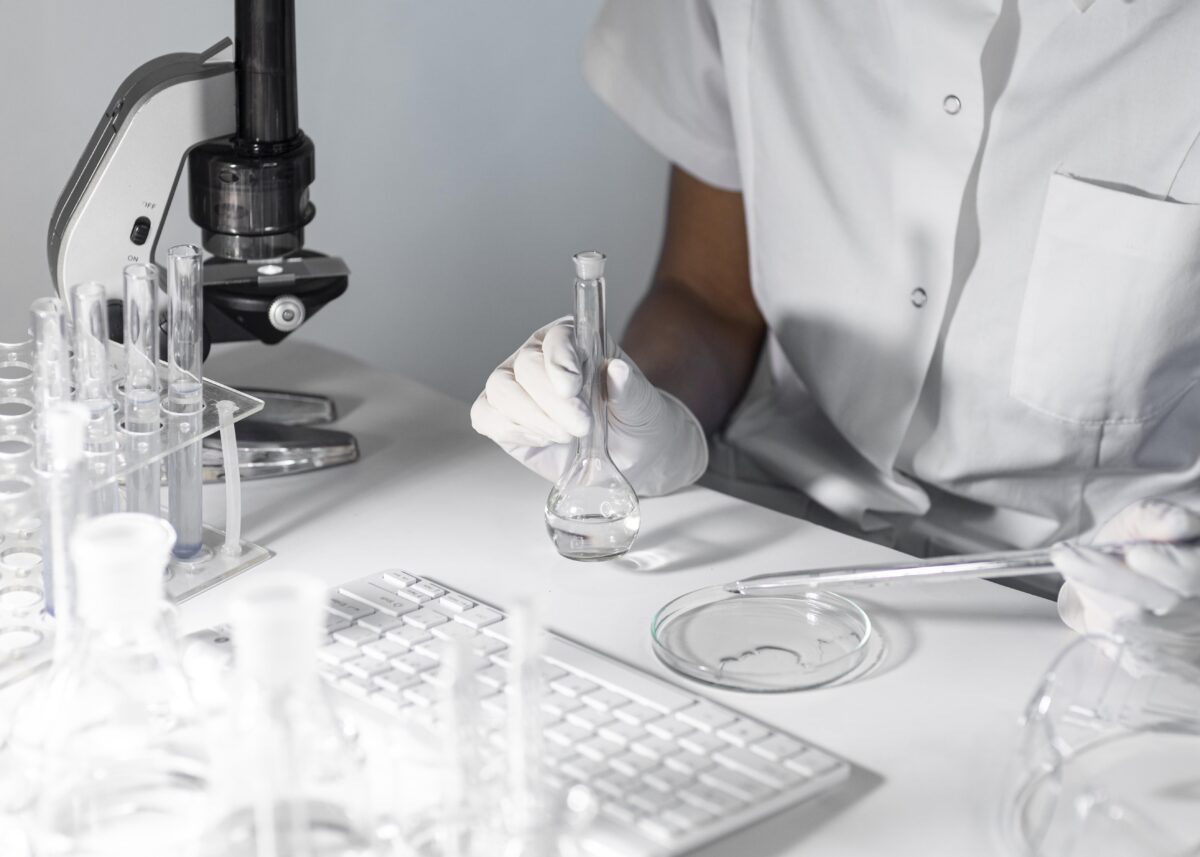 close-up-scientist-holding-glassware-1200×857